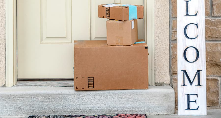 Boxes by the door of a residence with a welcome sign in San Diego